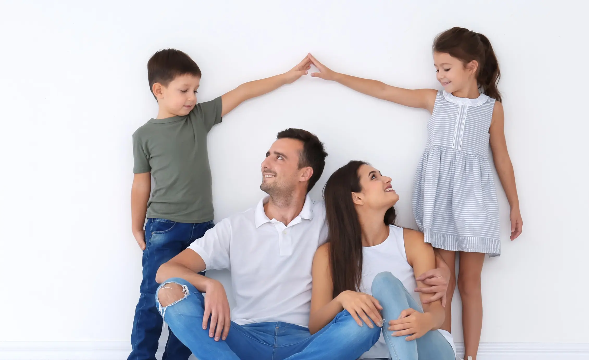 A happy family making a house shape with their hands