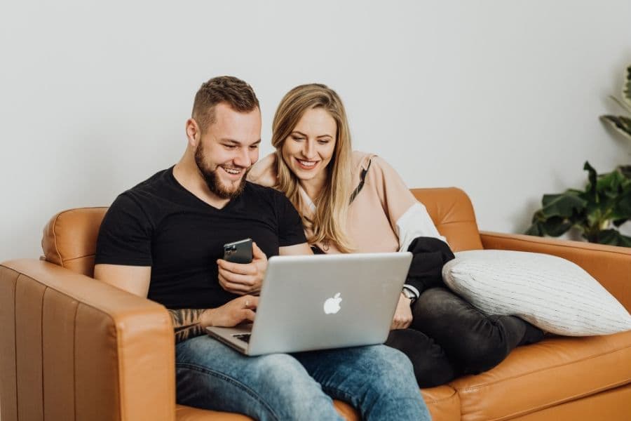 Young couple reviewing first-time home buyer mortgage options together on a laptop