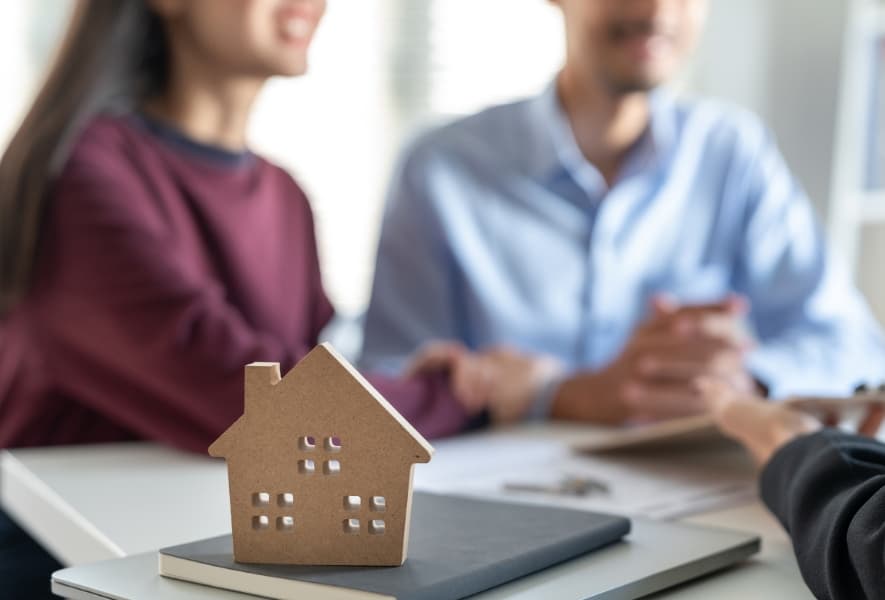Homeowners reviewing mortgage options with a broker at a desk